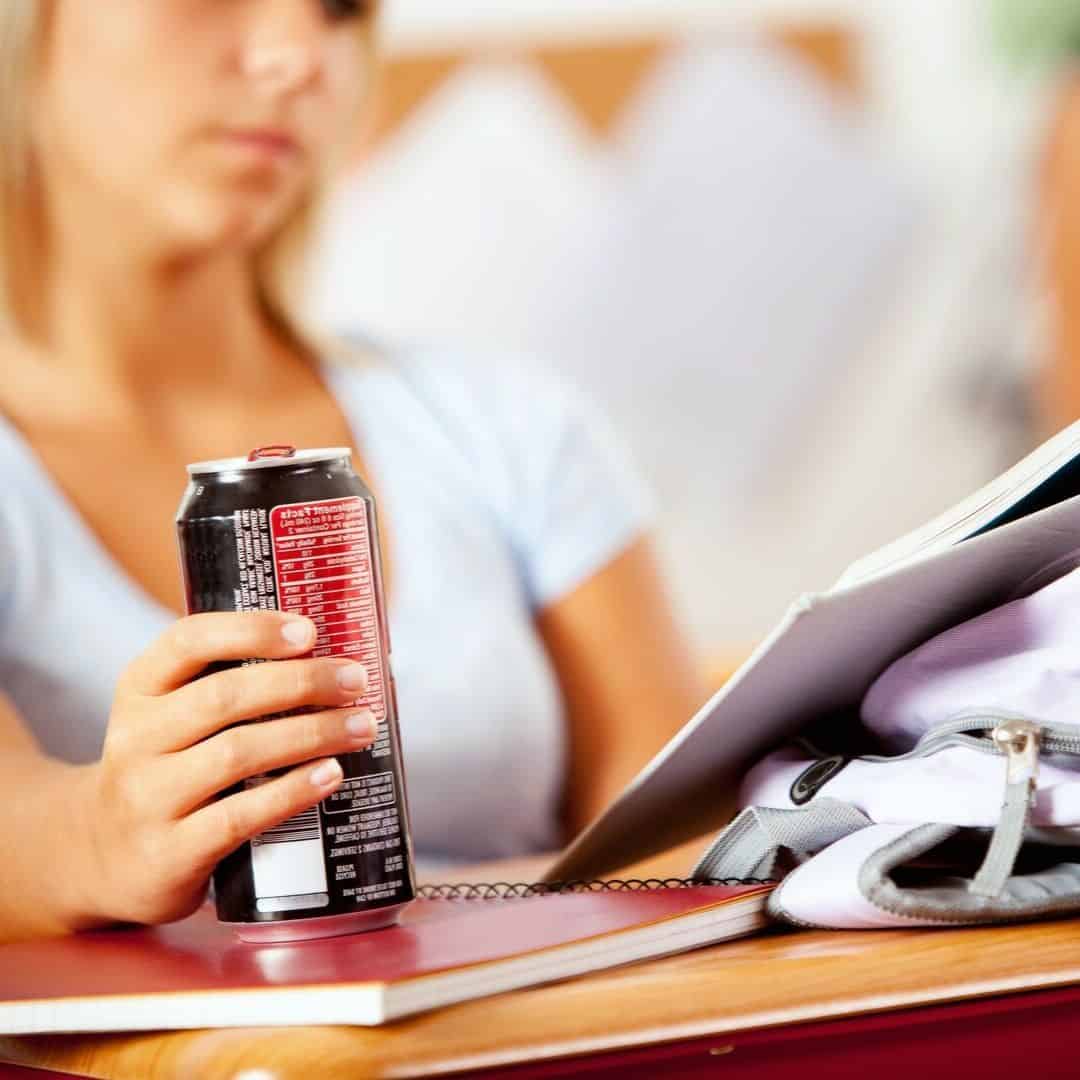 Woman drinking energy drink when studying