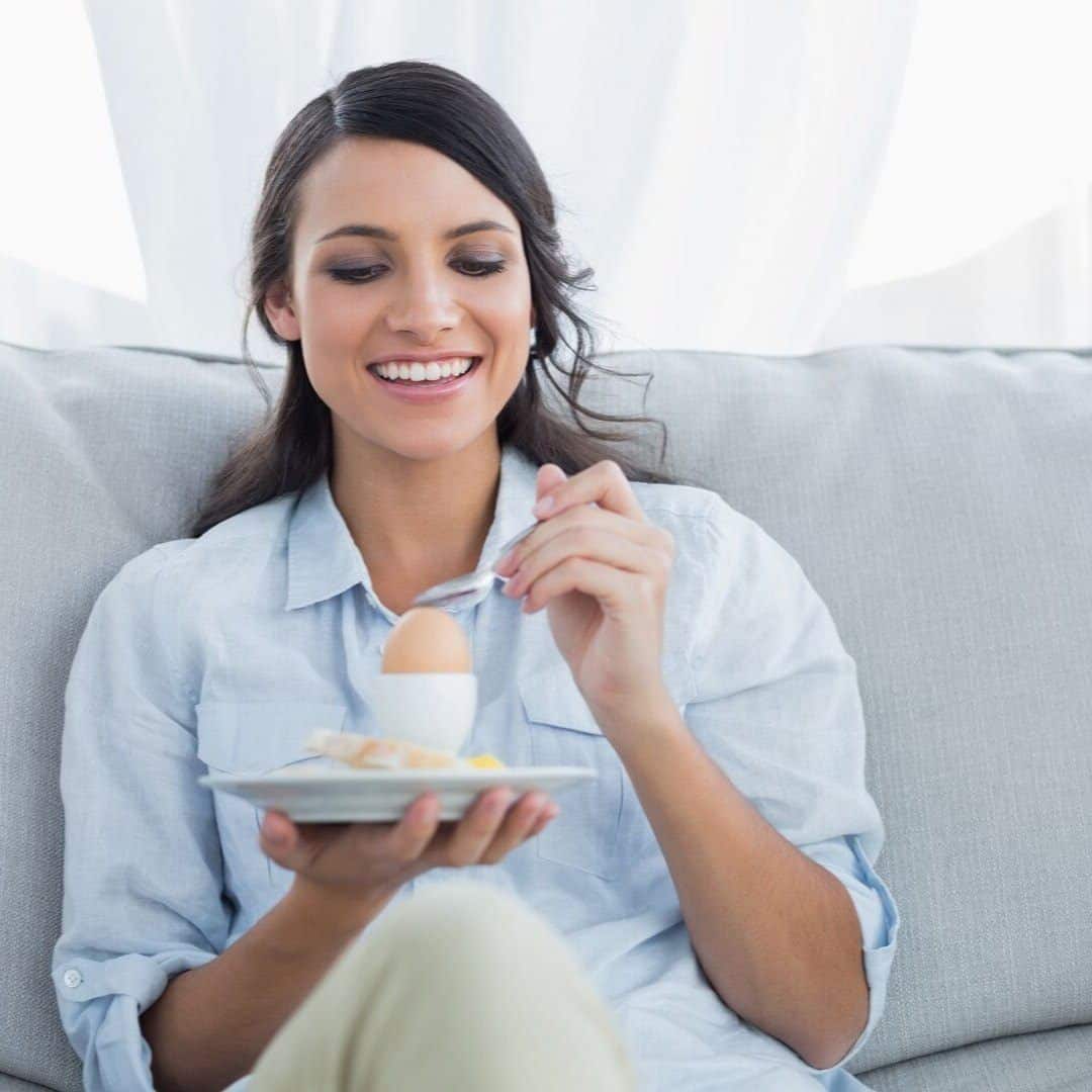 A woman eating an egg