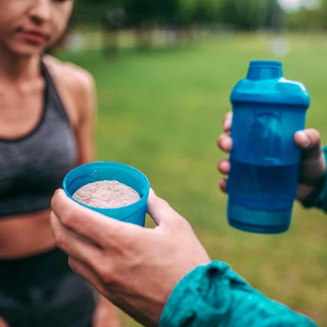 A woman taking protein after running