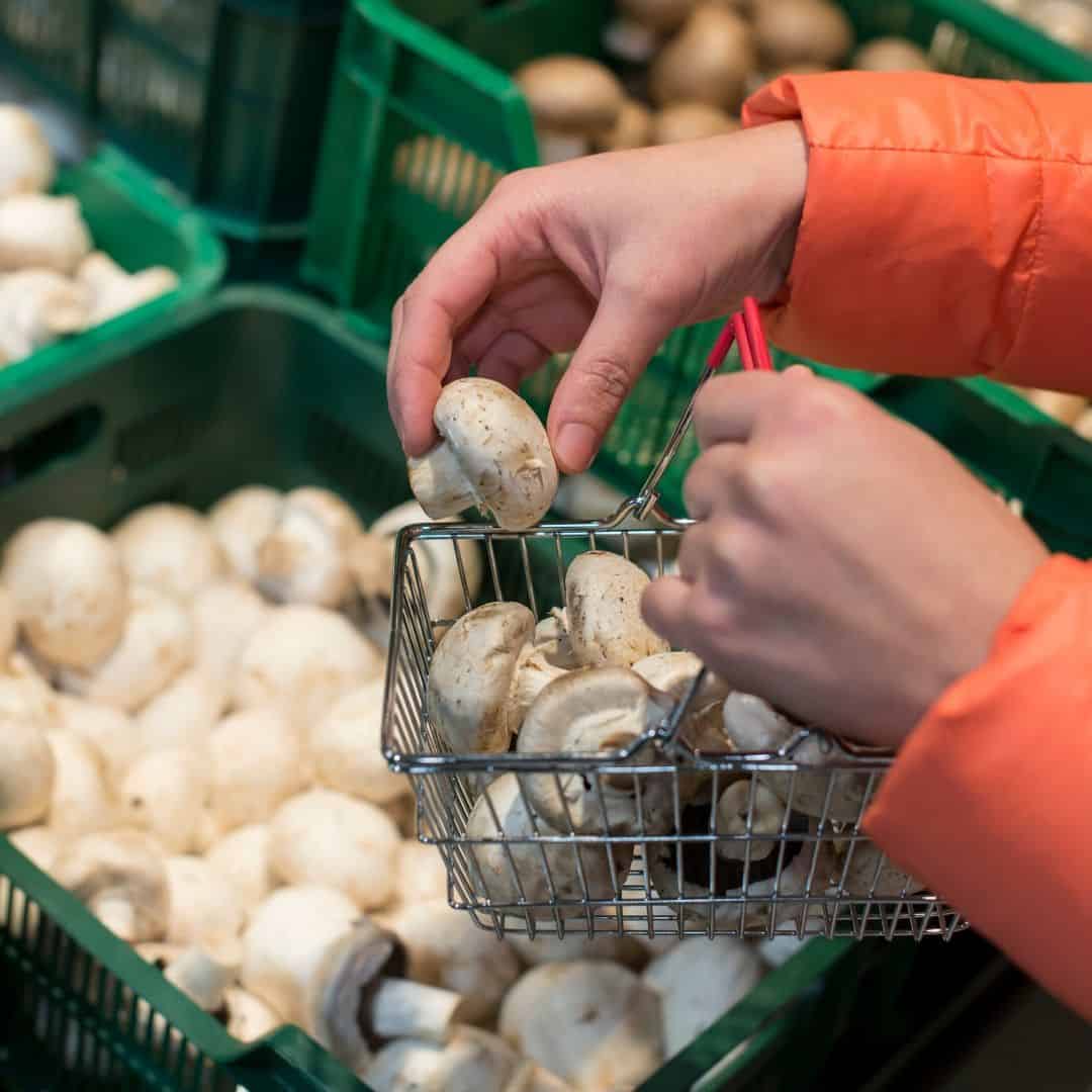 A woman buying mushrooms at the market