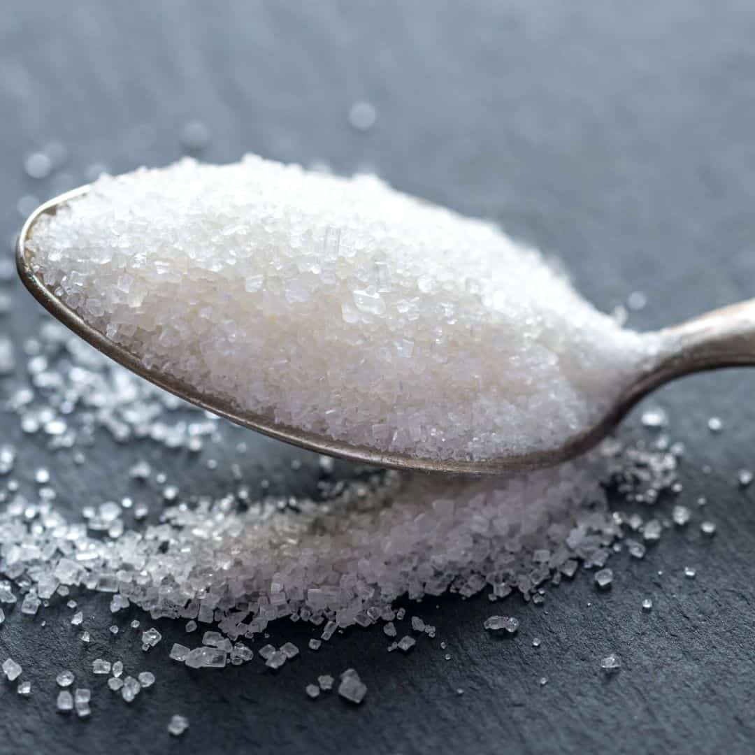 a spoon full of white table sugar