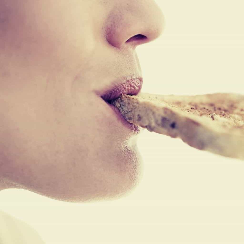 a woman eating moldy slice of bread