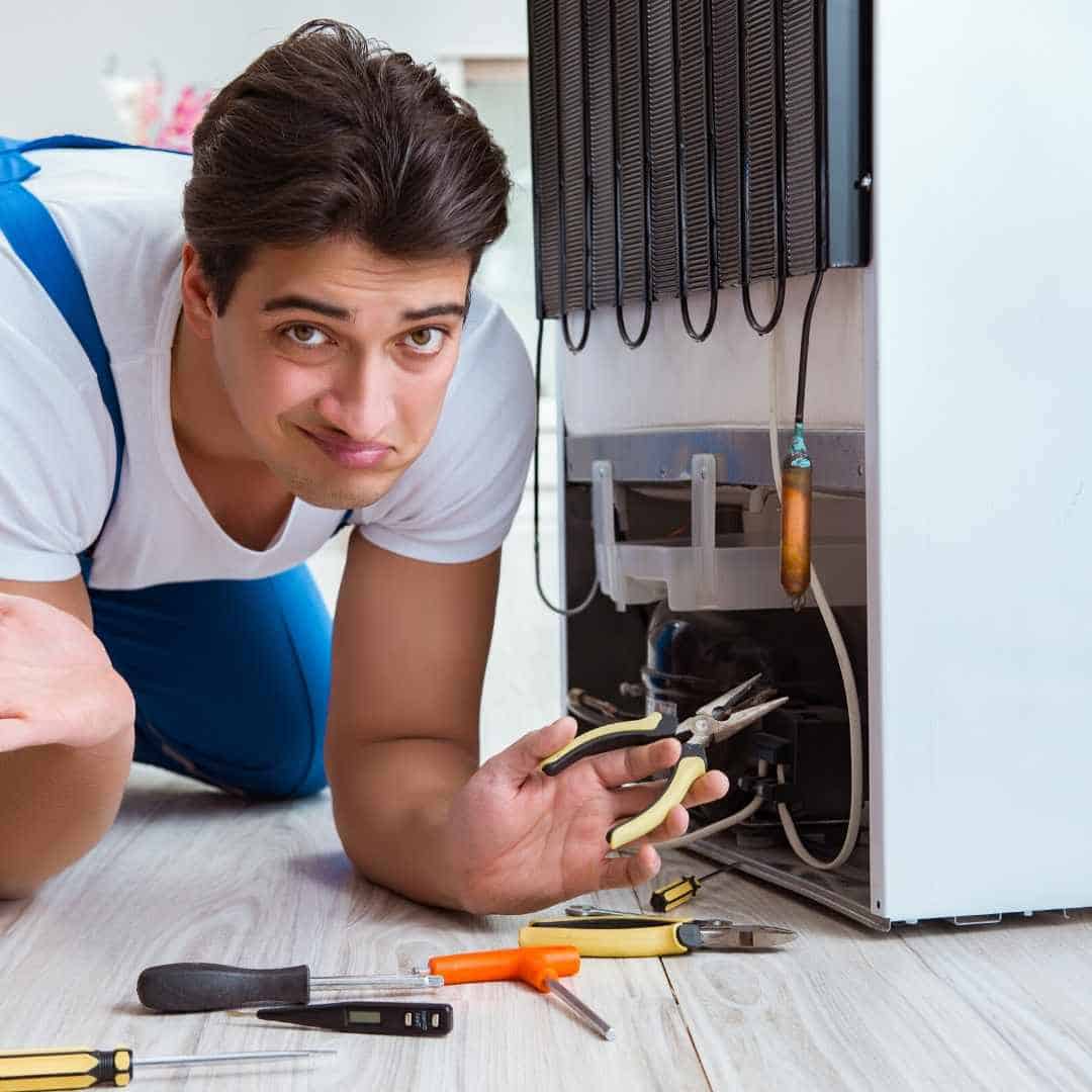 engineer is trying to fix the refrigerator