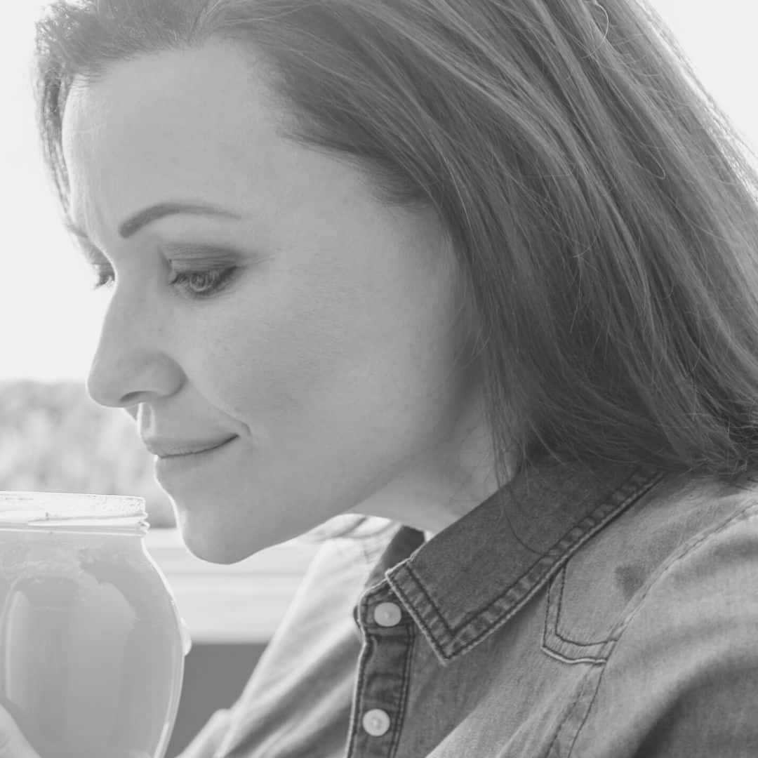 a woman smelling a opened jar of mayonnaise