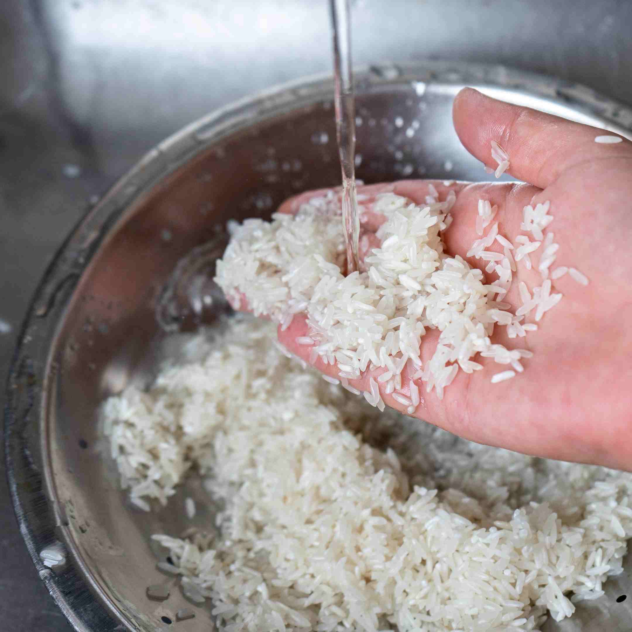 rinsing rice in a fine-mesh strainer under cold running water before cooking