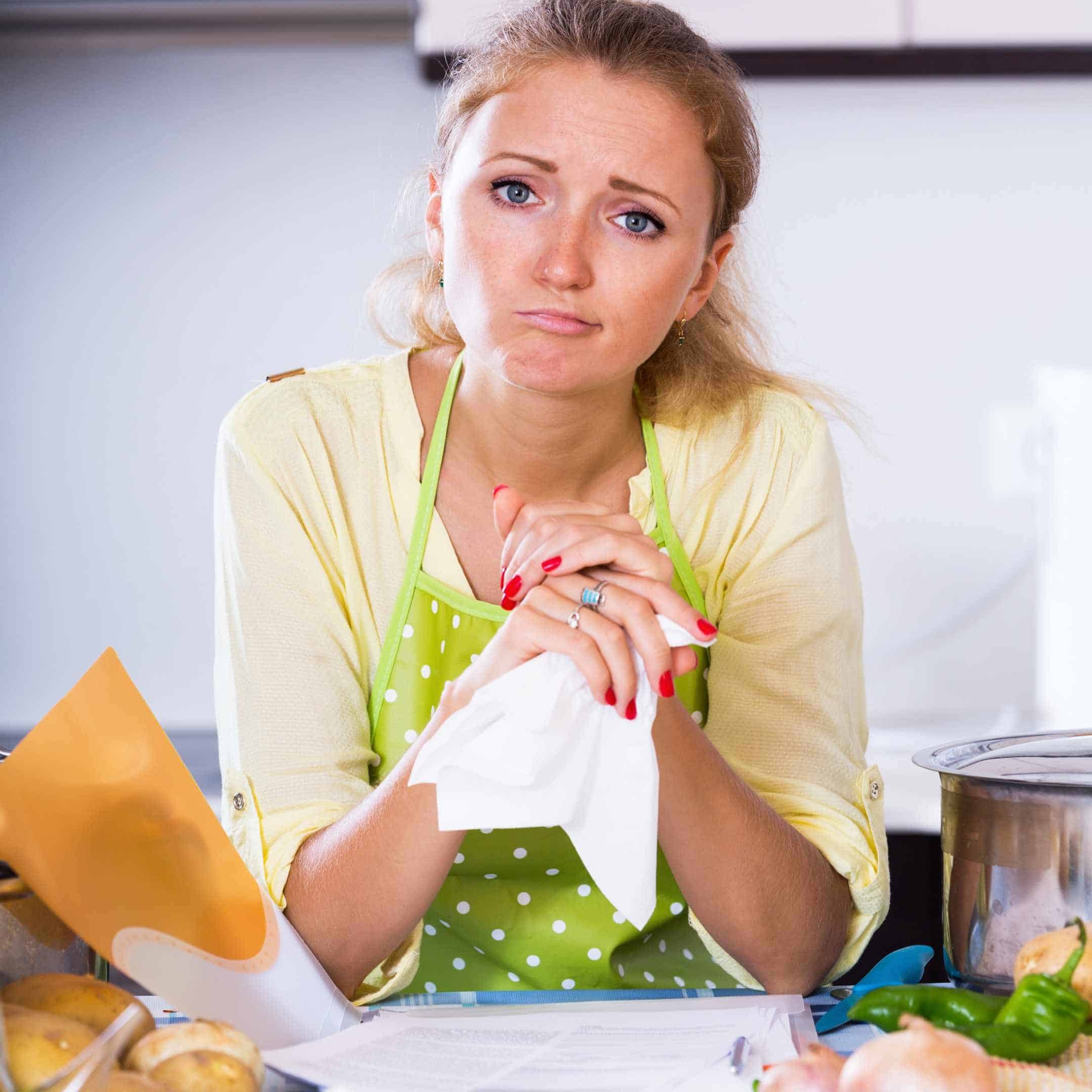 a disappointed woman sitting in the kitchen