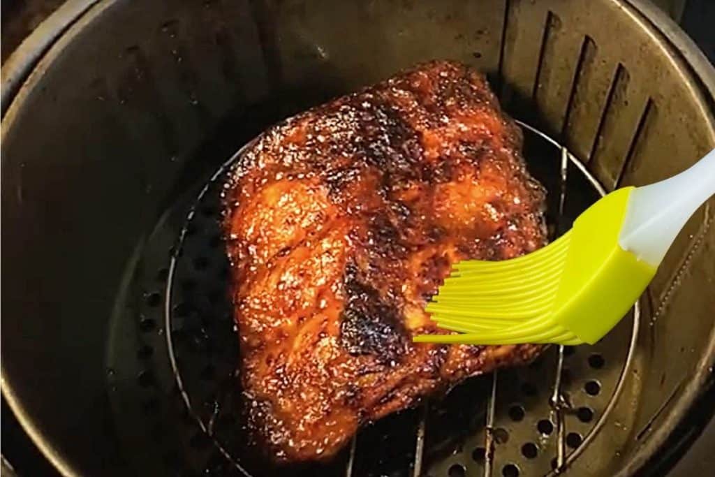 brushing cooking oil into ribs in air fryer before reheating