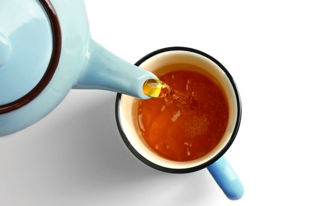 pouring a fresh cup of tea in a cup