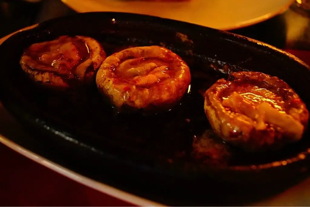 roasted flat mushrooms served with a pasta dish