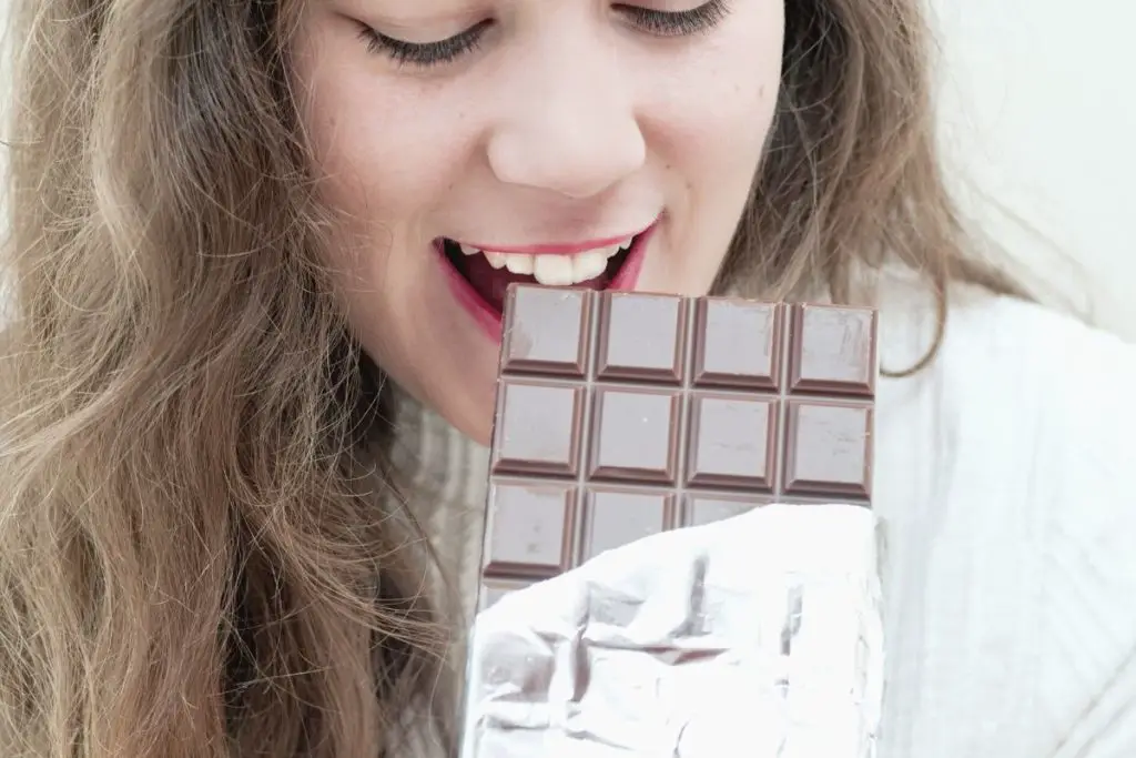 woman eating chocolate at night