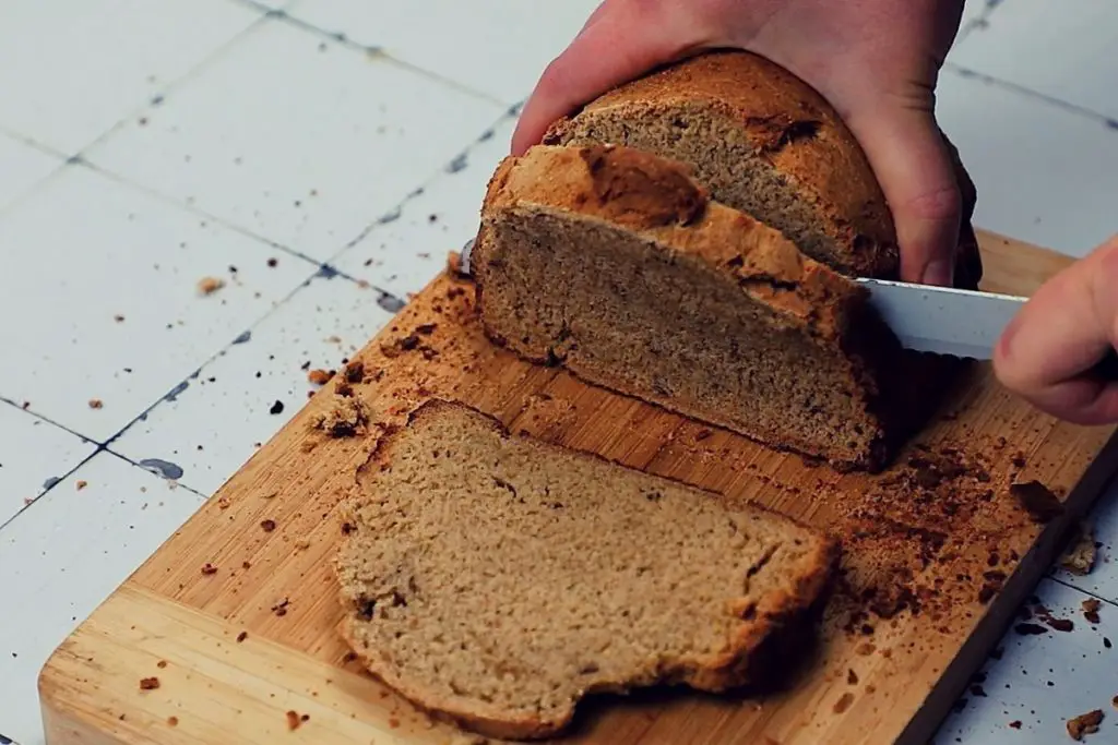cutting a slice of fresh homemade rye bread 
