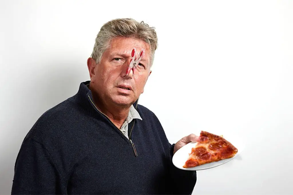 man holding a slice of spoiled pizza