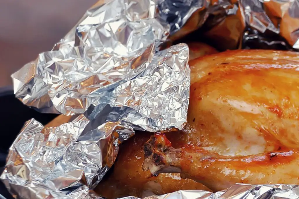 cooked turkey wrapped in aluminum foil to keep it warm