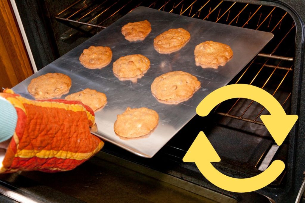 rotating the cookie tray in the oven for even baking