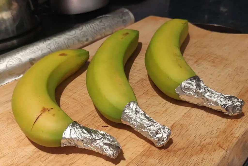 banana stems wrapped in aluminum foil to stop the releasing ethylene gas