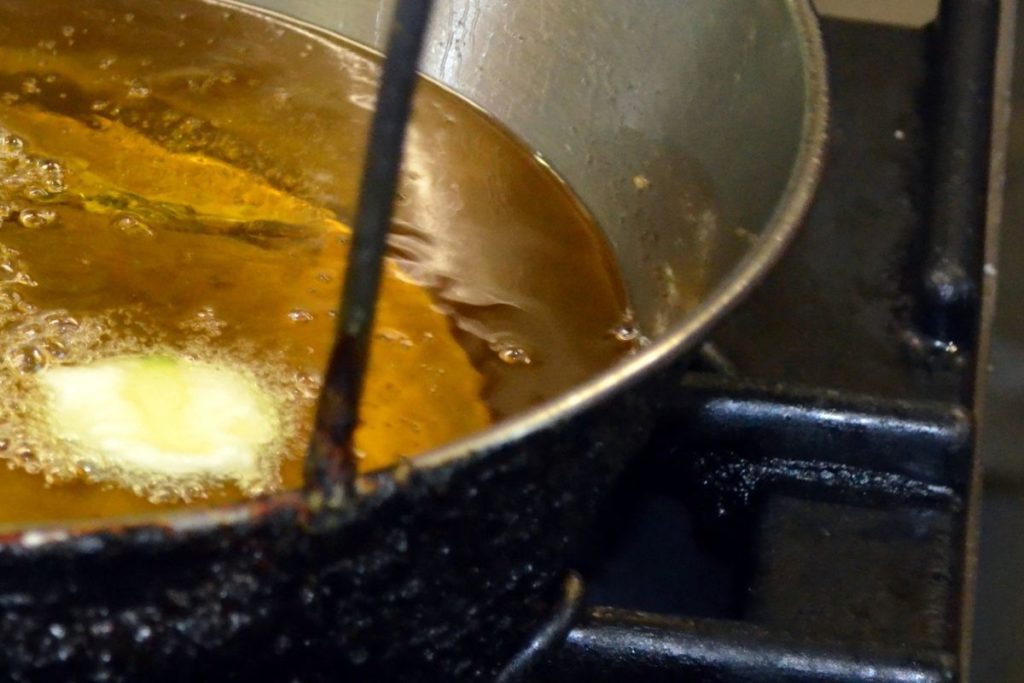 dropping a cube of bread into the hot oil and time how long it takes to turn golden brown