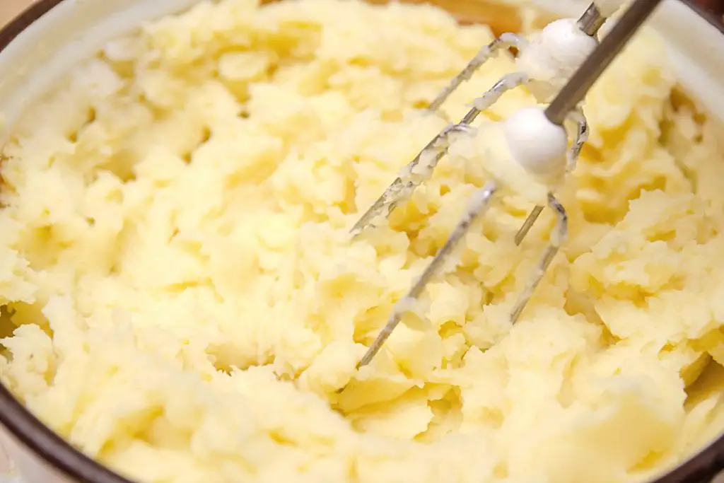 mixing cream cheese in mashed potato