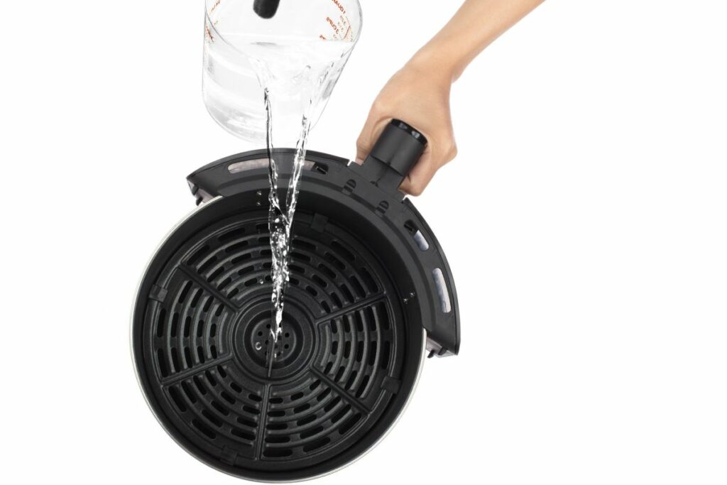 pouring water into the air fryer basket
