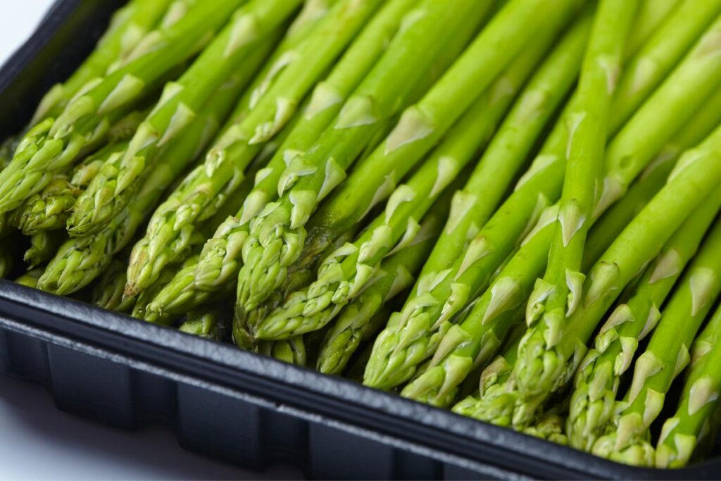 choosing fresh green asparagus at the grocery store