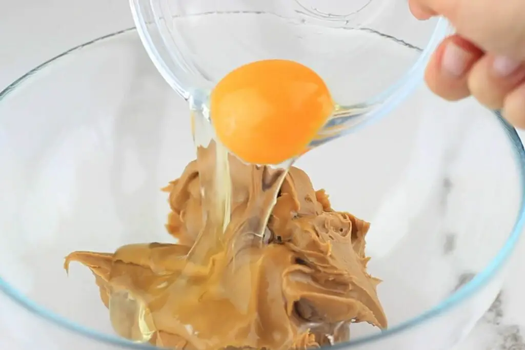 mixing peanut butter with an egg 
