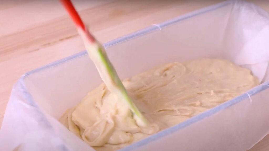 pouring the banana bread batter into a loaf pan