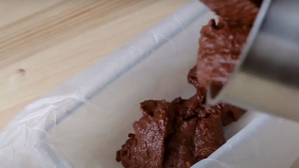 pouring the brownie mix into a cake pan