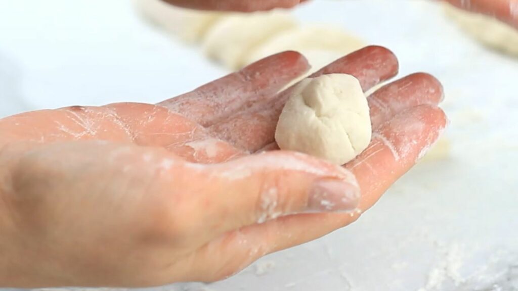 rolling the dough into doughnut balls