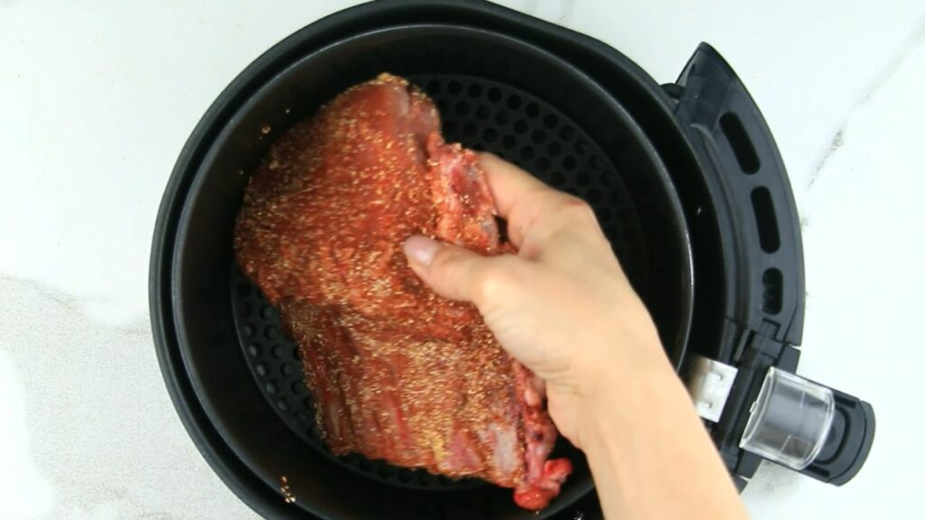 placing the ribs in the air fryer basket