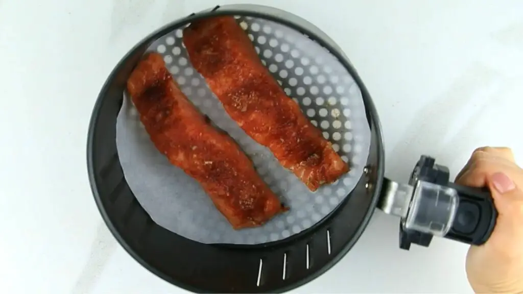 placing the salmon fillets into the air fryer basket 