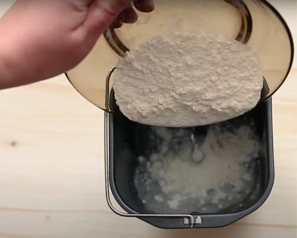 adding flour into the bread maker