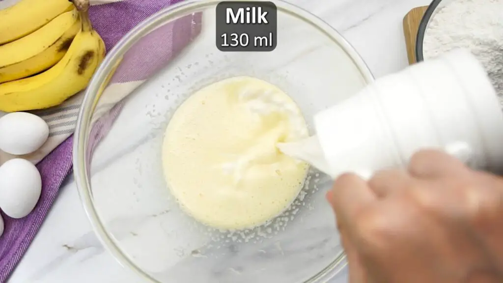 adding milk to banana cake batter