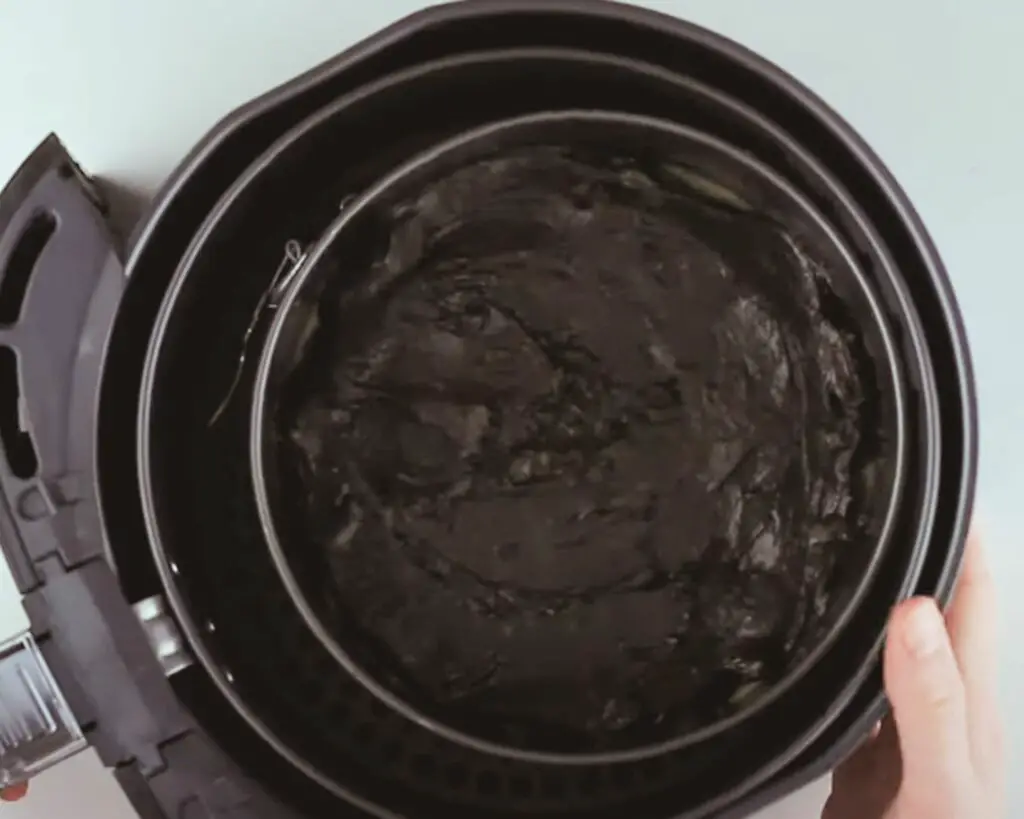 air fryer basket with the brownie batter in it