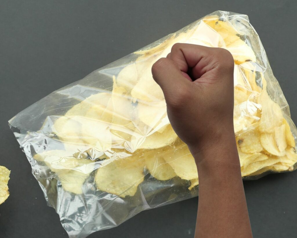 crushing potato chips in a bag