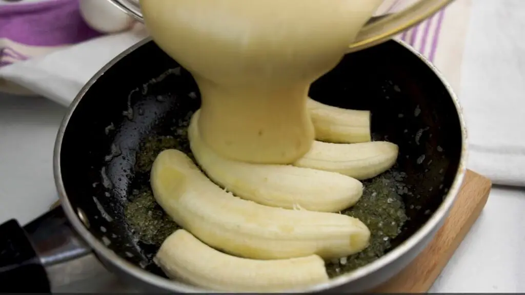 pouring the cake batter over the bananas