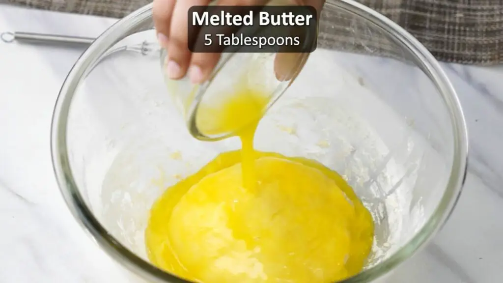 Adding the melted unsalted butter to the dough