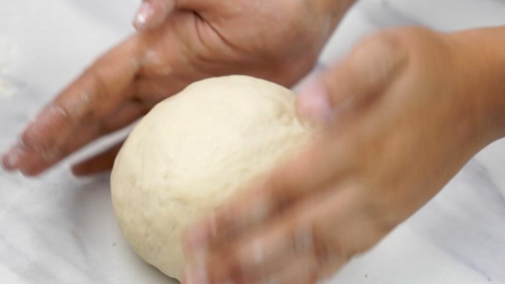Taking the dough out of the bowl and put it on a lightly floured surface