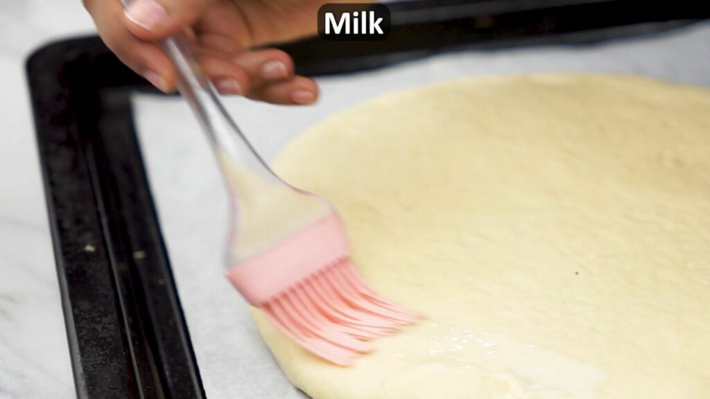 brushing the bread with milk wash before baking