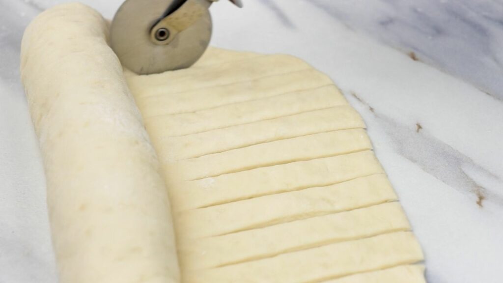 cutting the end of the dough into ribbons