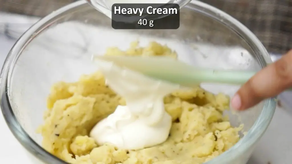 mixing in the heavy cream into the mashed potato filling 