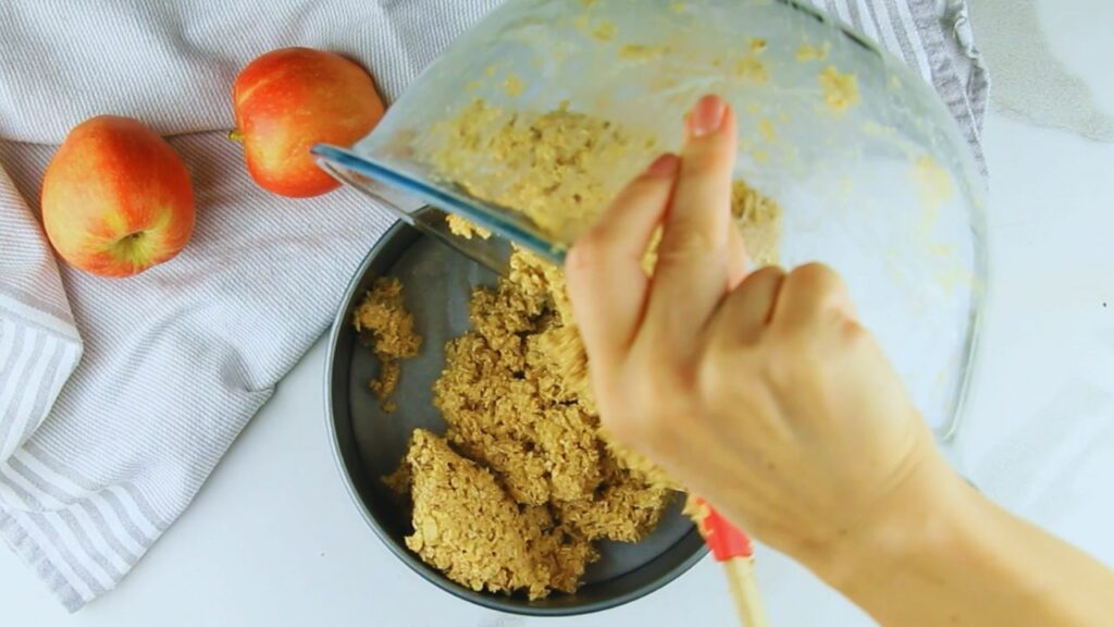 pouring the oat apple cake batter into the baking tin