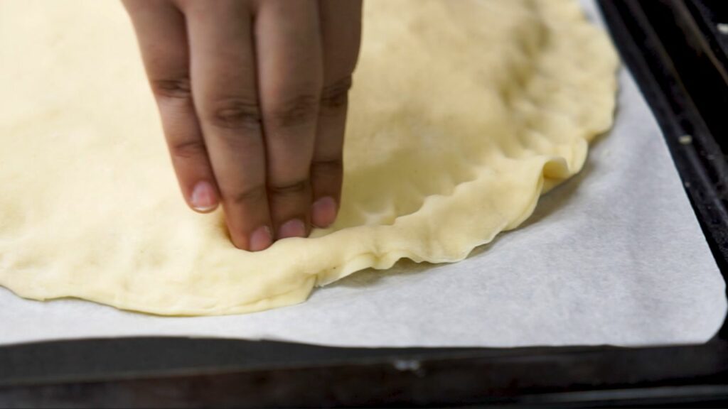 pressing down the edges of the dough