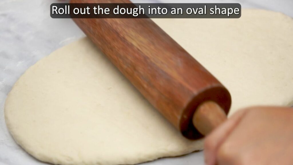 rolling the bread dough into an oval shape