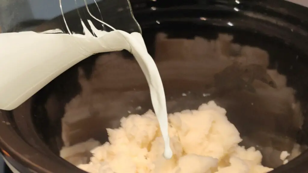adding milk to mashed potatoes