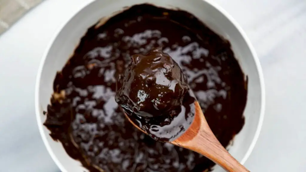 dipping each protein ball into the chocolate mixture