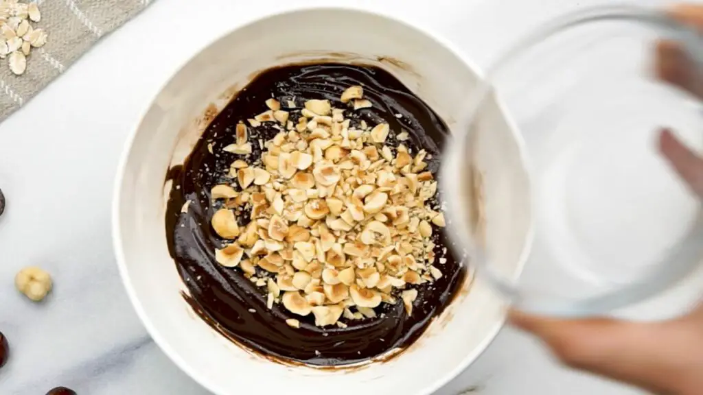 mixing chopped hazelnuts with dark chocolate