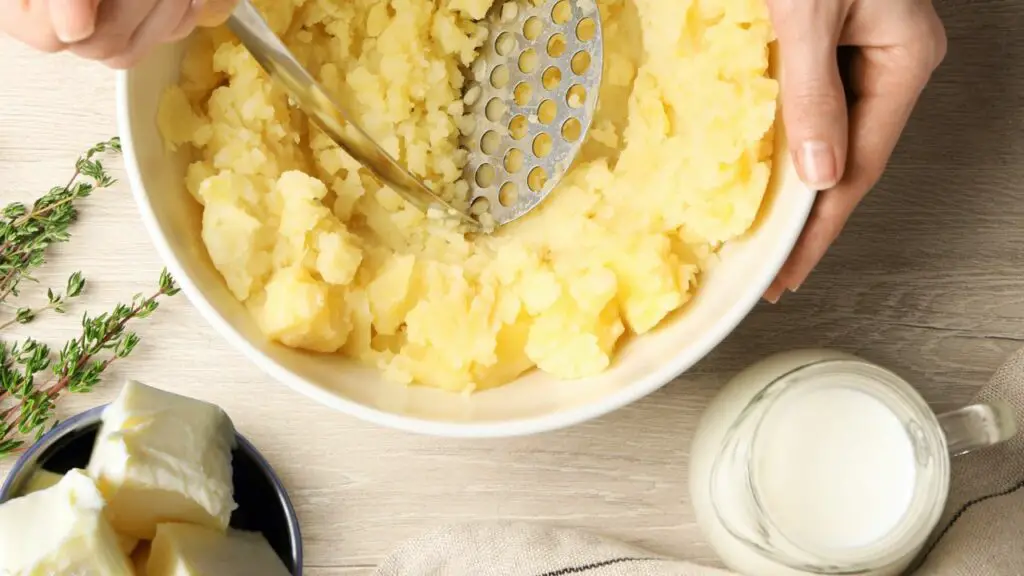 adding milk and butter to mashed potatoes