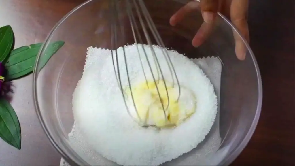 mixing white sugar and butter using a whisk