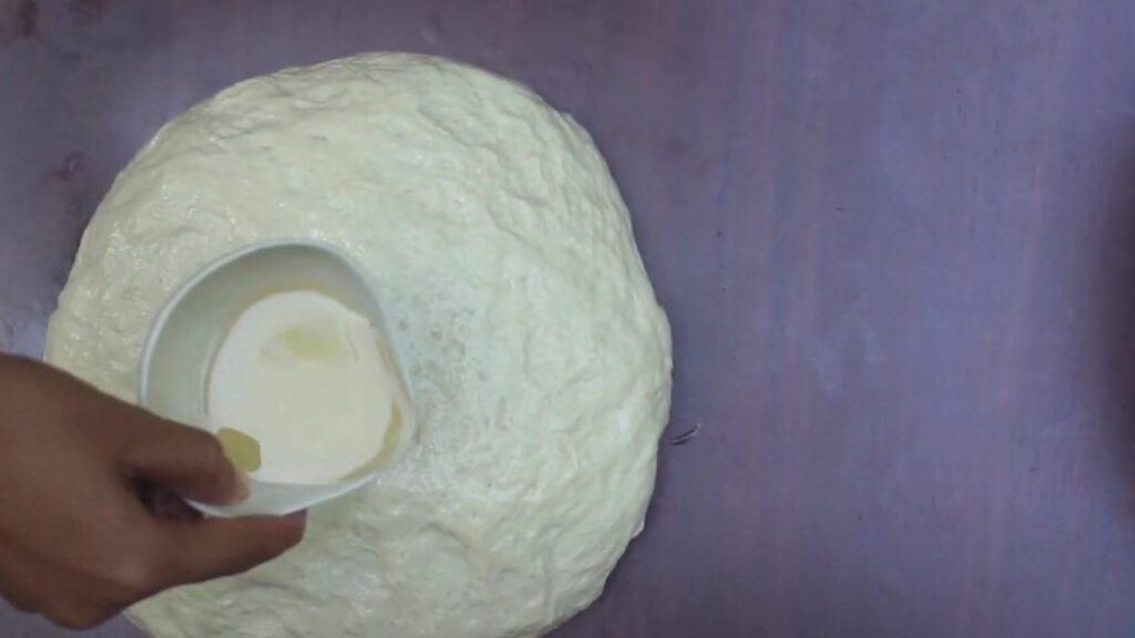 pouring the coconut oil into the surface of the dough