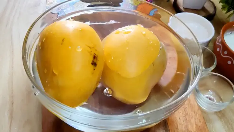 two mangoes in a bowl with water