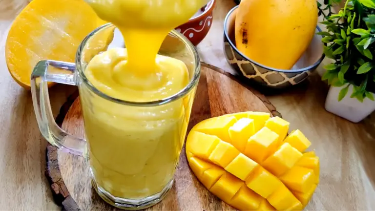 transferring mango lassi in a glass